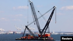 Large cranes arrive in the Patapsco River near the collapsed Francis Scott Key Bridge in Baltimore, Maryland, on March 29, 2024.