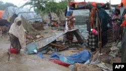 FILE - Members of a family stand next to their makeshift house that was swept at the internally displaced people (IDP) camp in Hodon district in Mogadishu, Somalia, May 30, 2015, following heavy rain that has pounded the parts of the country. United Nations predicts that up to 900,000 people could be hit by the strongest El Niño weather phenomenon in decades.