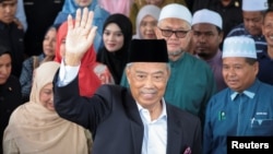 Malaysian opposition leader and former premier Muhyiddin Yassin waves as he leaves the Gua Musang Sessions Court in Gua Musang, Malaysia, Aug. 27, 2024.