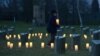A Child brings a candle to at a Jewish cemetery at the former Terezin Nazi concentration camp on January 27, 2015, in Terezin (Theresiendstadt ) during the ceremony to mark the 70th anniversary of the liberation of the former Nazi concentration camp Ausch