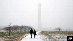 El monumento a George Washington en Washington, D.C. es visitado aún durante la nevada que afecta la capital de EE.UU.