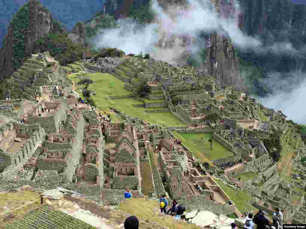 Machu Picchu in Peru as seen from the Sun Gate &ndash; the end of the Inca Trail, featuring breathtaking views of site, as the clouds part for a golden sunrise. (Photo taken by Carolyn Presutti)