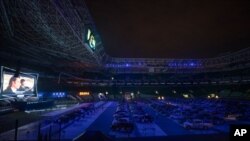 People watch a movie from inside their cars at a drive-in installed in the Palmeiras soccer stadium amid the coronavirus outbreak in Sao Paulo, Brazil, June 25, 2020. 