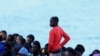 Sejumlah migran menunggu untuk turun dari perahu kayu di pelabuhan Arguineguin, Pulau Gran Canaria, Spanyol, pada 20 Oktober 2024. (Foto: Reuters/Borja Suarez)