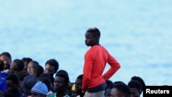 Sejumlah migran menunggu untuk turun dari perahu kayu di pelabuhan Arguineguin, Pulau Gran Canaria, Spanyol, pada 20 Oktober 2024. (Foto: Reuters/Borja Suarez)