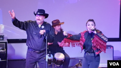 Vokalis Dangdut Cowboys Andrew Weintraub (kiri) dan pedangdut Fitri Carlina (kanan) berduet dalam Dangdut USA di @america, Jakarta, Sabtu (16/3/2019) malam. (VOA/Rio Tuasikal)