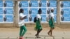 FILE - Schoolgirls walk past election posters of Togo's incumbent President Faure Gnassingbe, presidential candidate of Union for the Republic, on the street in Lome, Togo, Feb. 21, 2020.