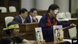 Hong Kong legislator Raymond Wong Yuk-man, right, speaks next to legislator Leung Kwok Hung, left during a parliamentary debate in the Hong Kong Legislative Council Wednesday, Nov. 3, 2010. Hong Kong's pro-democracy lawmakers challenged Beijing's condemna