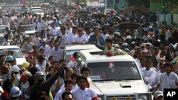 Burma's pro-democracy leader Aung San Suu Kyi waves her hand to supporters on her arrival in Dawei, about 615 km (380 miles) south of Rangoon, January 29, 2012.