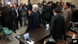 Iranian President Hassan Rouhani waves to media as he arrives at the Interior Ministry to register his candidacy for the May 19 presidential elections, in Tehran, Iran, April 14, 2017