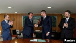 Brazil's President Jair Bolsonaro shakes hands with the new head of the federal police Rolando Alexandre de Souza at the Planalto Palace in Brasilia, Brazil, May 4, 2020.