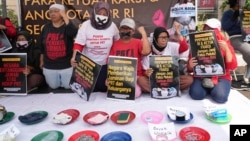 Para aktivis membawa poster-poster dan memamerkan barang-barang rumah tangga dalam demo di depan gedung DPR/MPR untuk menuntut DPR agar mengesahkan RUU Perlindungan Pekerja Rumah Tangga menjadi undang-undang, Jakarta, 14 Agustus 2023. (Foto: Tatan Syuflana/AP Photo)