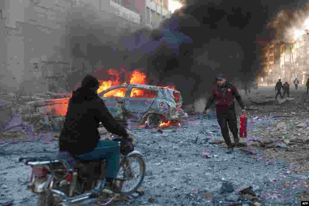 People try to extinguish fires following an airstrike that targeted Syria&#39;s rebel-held northern city of Idlib.