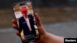 Una mujer posa con su teléfono inteligente mostrando la página de TikTok @realdonaldtrump, en Washington, EEUU, el 19 de enero de 2025.