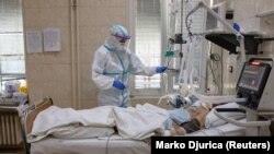 Medicinski radnik pored pacijenta obolelog od koronavirusa, u Klinici za infektivne i tropske bolesti Kliničkog centra Srbije, u Beogradu, 24. aprila 2020. (Foto: Rojters, Marko Đurica)