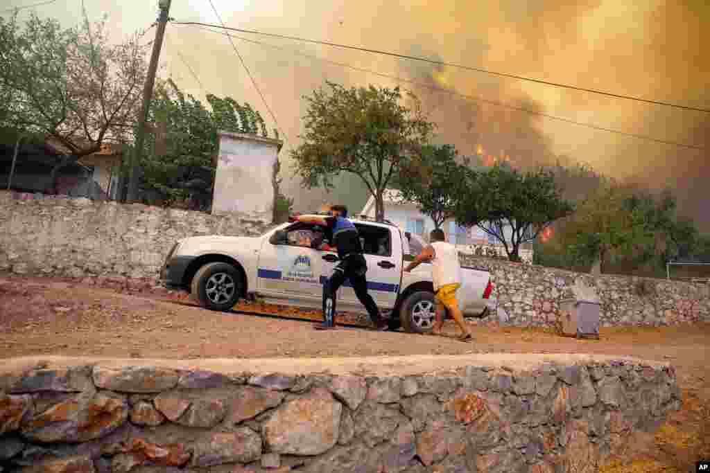 People run away from an advancing fire in Cokertme village, in Bodrum, Mugla, Turkey.