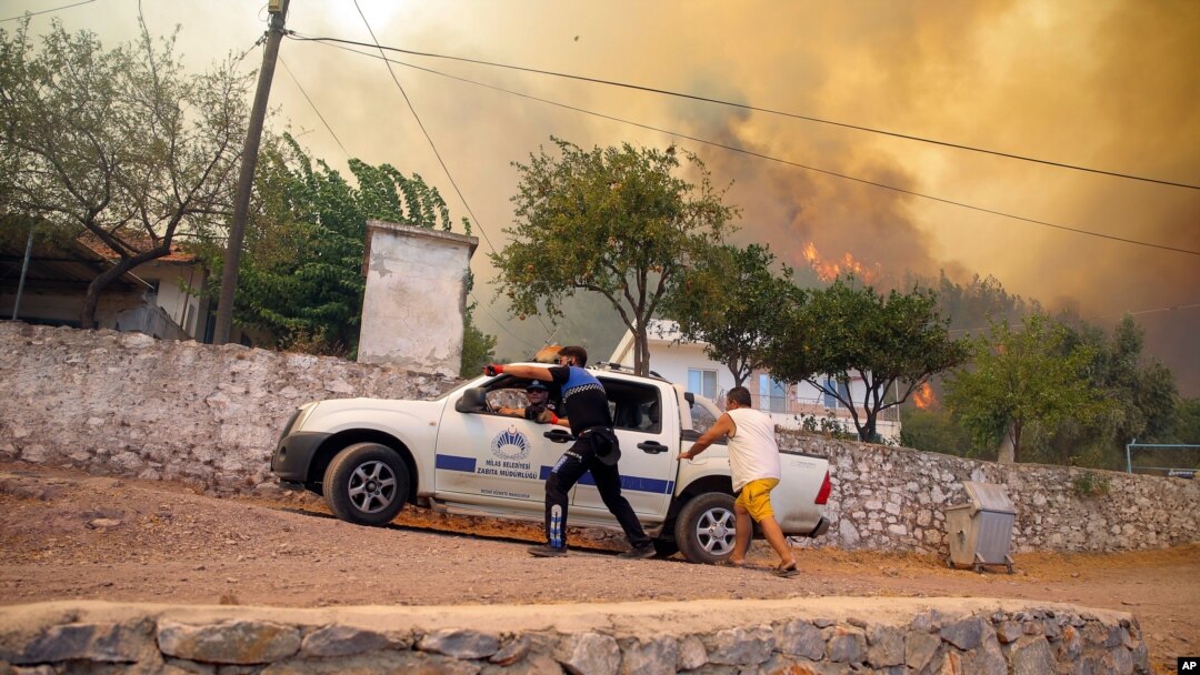 Orang-orang lari menyelamatkan diri dari api kebakaran hutan di Desa Cokertme, di Bodrum, Mugla, Turki, Senin, 2 Agustu 2021.