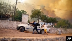 Orang-orang lari menyelamatkan diri dari api kebakaran hutan di Desa Cokertme, di Bodrum, Mugla, Turki, Senin, 2 Agustu 2021.