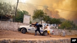 People run away from an advancing fire in Cokertme village, in Bodrum, Mugla, Turkey, Aug. 2, 2021.