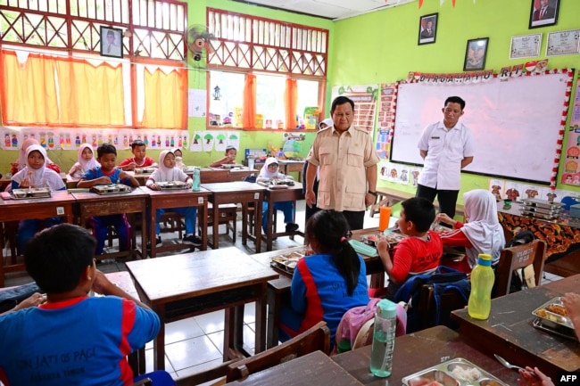 FILE - Presiden Indonesia Prabowo Subianto (kedua dari kanan) meninjau pelaksanaan program makanan bergizi gratis (MBG) di sebuah ruang kelas Sekolah Dasar Negeri Jati 05 Pagi, Jakarta Timur, 3 Februari 2025.. (Handout / Istana Kepresidenan Indonesia / AFP)