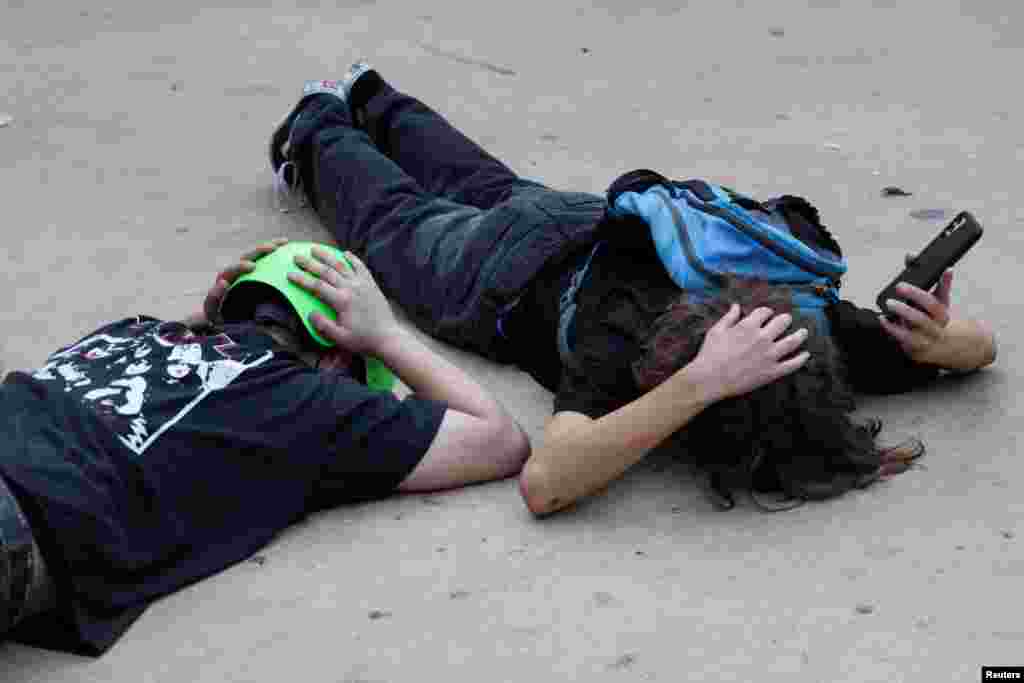 People take cover as sirens sound in central Israel in response to what Israel&#39;s military says projectiles fired from Lebanon, in Tel Aviv.