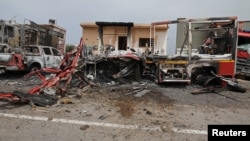FILE - Damaged vehicles and buildings are seen at Mitiga airport after it was hit by shelling, in Tripoli, Libya, May 10, 2020. 