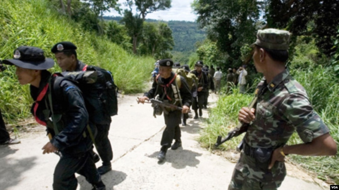 Seorang tentara Kamboja (kanan) mengamati para tentara Thailand yang melewati perbatasan yang disengketakan (foto: dok.)
