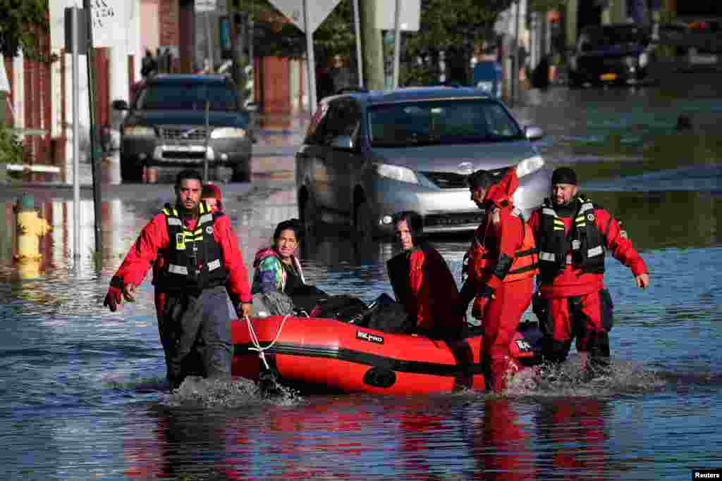 First responders pull local residents in an inflatable boat as they rescue people trapped by floodwaters after the remnants of Tropical Storm Ida brought drenching rain, flash floods and tornadoes to parts of the northeast, in Mamaroneck, New York.