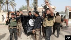 Pasukan Irak merayakan kemenangan setelah berhasil merebut kembali kota Ramadi, dan menurunkan bendera milik kelompok militan ISIS (foto: dok).