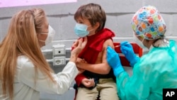 A boy receives a dose of Pfizer-BioNTech COVID-19 vaccination for children aged 5-11, in Rome.