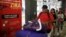 FILE - Travelers walk past a poster with information about the Zika virus during a campaign by Peru's Health Ministry at Plaza Norte bus station in Lima, Peru, Feb. 4, 2016. 
