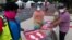 Members with the Washington, D.C. Dept. of Health, prepare to place new signs at their F Street COVID-19 testing location, Aug. 14, 2020, in Washington. This location tests approximately 450-500 people a week and has been open since June 1st. (AP…