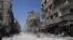 In this photo taken during a Syrian government-led media tour, buildings damaged during battles between Syrian troops and rebels stand along an empty street in Mleiha, about 10 kilometers (6 miles) southeast of downtown Damascus, Syria, Aug. 15, 2014. 