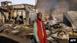 FILE - A man walks in front of some heavily damaged houses and shops in the area where he lives, the day after a gas explosion created severe damages in the Embakasi area of Nairobi on February 2, 2024.