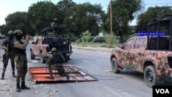 Haiti's National Police guard remove makeshift barricades made of steel fences and tree branches protesters placed to block the National Palace entrance, Oct. 31, 2019. (Photo: Matiado Vilme / VOA) 