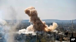 In this photo released by the Syrian official news agency SANA, smoke rises after Syrian government airstrikes and shelling hit in Hajar al-Aswad neighborhood held by Islamic State militants, southern Damascus, April 22, 2018.