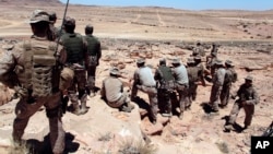 FILE - U.S. Marines monitor Eager Lion multinational military maneuvers in Quweira, 186 miles south of Amman, Jordan, June 18, 2013. The Obama administration used U.S. military trainers to help increase the capabilities of the Syrian rebels.