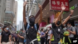 Protesters gesture with five fingers, signifying the "Five demands - not one less" as they march along a downtown street during a pro-democracy protest against Beijing's national security legislation in Hong Kong, Sunday, May 24, 2020. Hong Kong's…