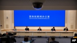 资料照片：2021年3月24日，中国学者和政府官员在北京国务院新闻办公室的新闻发布会上。（美联社照片）
