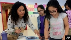 Nelba Marquez-Greene helps 10-year-old Araceli Buchko put her hand print inside a giant paper heart as part of the Love Win's campaign's Friendship Day, a social and emotional learning activity at the Chamberlain Elementary School in New Britain, Conn., Feb. 14, 2017.
