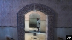 FILE — A worker walks inside an empty Moroccan traditional bath, known as hammam, in Rabat, Morocco, March 4, 2024. Climate change and a yearslong drought have forced Morocco's famous public baths to close a few days a week in an effort to save water.