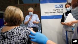  آغاز رسمی واکسیناسیون کووید۱۹ در بریتانیا. بوریس جانسون نخست وزیر بریتانیا پس از تزریق واکسن برای پرستار دست می زند - ۸ دسامبر ۲۰۲۰