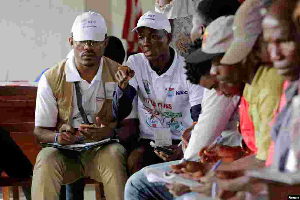 Two observers are seen during presidential elections at a polling station in Monrovia, Oct. 10, 2017.