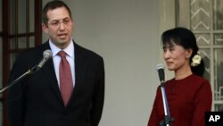 Derek Mitchell, left, U.S special envoy to Burma, talks to journalists after meeting with Burmese opposition leader Aung San Suu Kyi, right, in Rangoon, March 14, 2012.