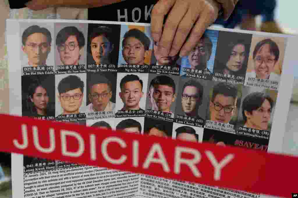 홍콩 법원 앞에서 한 운동가가 47명의 민주화 활동가 사진이 실린 포스터를 들고 있다. 
