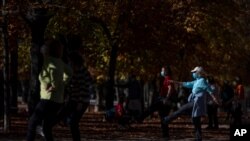 Unas personas portan mascarillas el miércoles 11 de noviembre de 2020 mientras se ejercitan en el parque del Retiro, en Madrid. 