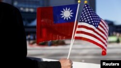 Seorang demonstran membawa bendera Taiwan dan AS saat Presiden Taiwan Tsai Ing-wen transit di Burlingame, California, tahun lalu dari perjalanan ke Amerika Latin. (Foto: ilustrasi).