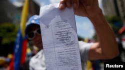 Una persona sostiene una copia de los registros electorales durante una marcha convocada por la oposición, en Caracas, Venezuela, el 17 de agosto de 2024.