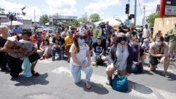 People kneel on the first anniversary of George Floyd's death, at George Floyd Square, in Minneapolis, Minnesota, U.S., May 25, 2021. (REUTERS/Nicholas Pfosi)