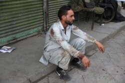 A blood-stained man rests after he helped people who were injured in a deadly bomb explosion in Kabul, Afghanistan, July 13, 2021.